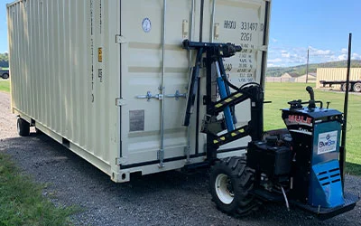 A plain colored storage container being accurately placed on stone using a mule device in Tioga County, PA